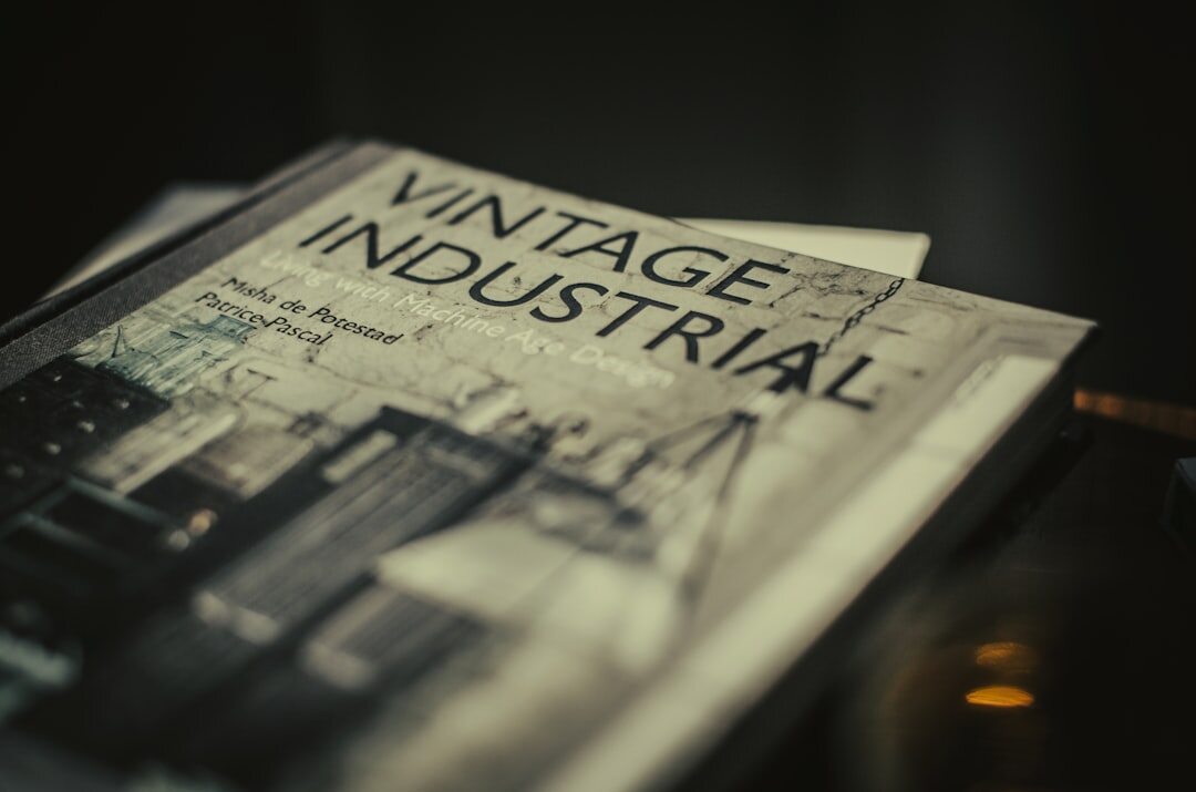 Stack of vintage magazines and photographic prints on a wooden desk